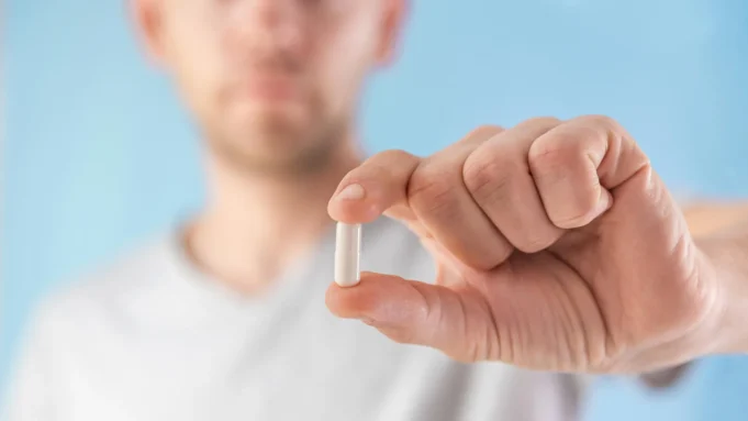 man-holding-supplement-capsule.webp.webp