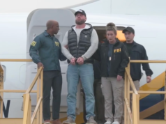 前奧運選手瑞安·婚禮被捕後由執法人員護送。